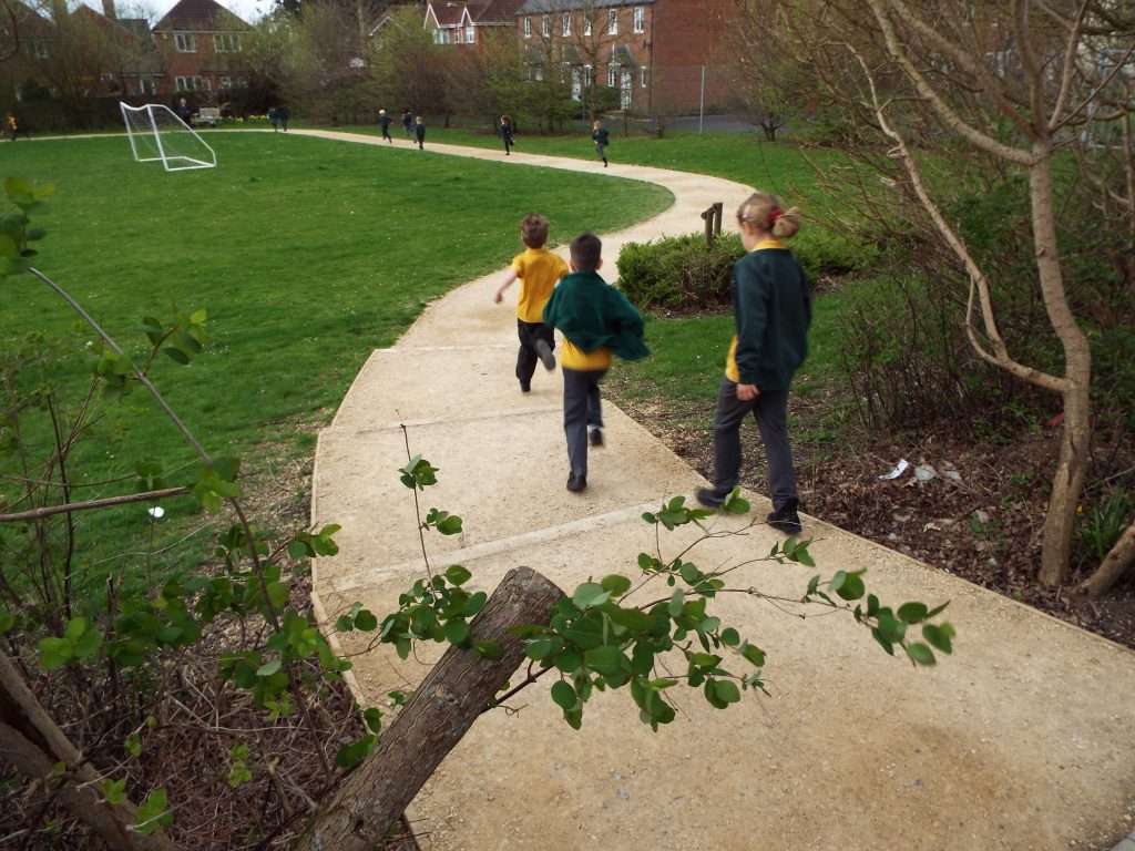 School grounds maintenance area with outdoor structures and maintained surfacing